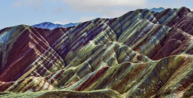 Gökkuşağı Dağı 'nın muhteşem manzarası ve gün batımında mavi gökyüzü arkaplanı. Zhangye Danxia National Geopark, Gansu, Çin. Renkli manzara, gökkuşağı tepeleri, sıra dışı renkli kayalar, kumtaşı erozyonu.