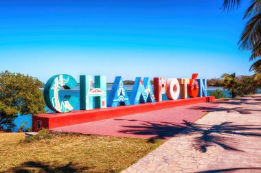 Big colorful block letters spelling Champoton offer tourists a selfie-photo opportunity with a beautiful blue sea in the background clipart