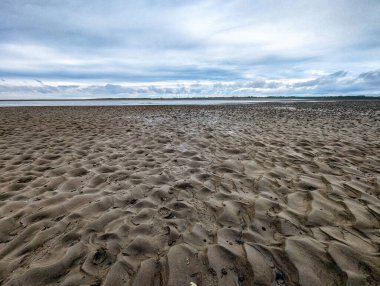 Hollanda Waddensea bölgesindeki Schiermonnikoog adasında kum desenleri. Schiermonnikoog, Frisian Wadden Adaları 'nın bir parçasıdır ve kumlu kumsallar, kayan kumullar ve yemyeşil sulak alanlar da dahil olmak üzere güzel doğal manzarasıyla ünlüdür..
