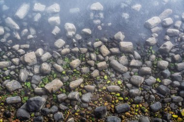 Dalgalar arasında denizde farklı boyutlarda kayalar var. Üst Manzara. Doğal arkaplan
