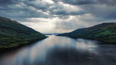Güzel Lomond Gölü, İskoçya, İngiltere 'de bir yaz günü nefes kesen bir manzarada su ve dağları gösteriyor. Popüler bir turizm merkezi..