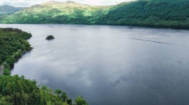Güzel Lomond Gölü, İskoçya, İngiltere 'de bir yaz günü nefes kesen bir manzarada su ve dağları gösteriyor. Popüler bir turizm merkezi..