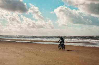 Hollanda plajında dağ bisikletçisi.