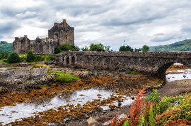 İskoçya 'nın Highlands bölgesinde Dornie, İngiltere yakınlarındaki Loch Duich, Loch Long ve Loch Alsh arasındaki gelgit adasında yaya köprüsüne sahip Eilean Donan şatosu.