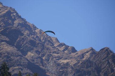 Gökyüzü dalgıcı yüksek dağların üzerinde uçuyor
