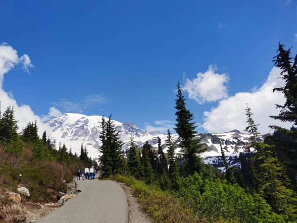 アスファルトの道を歩く観光客山と青空の美しい風景 — ストック写真