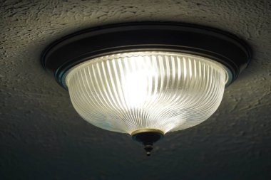 Tavanda yanan bir lamba.