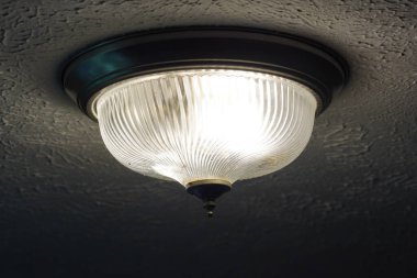 Tavanda yanan bir lamba.