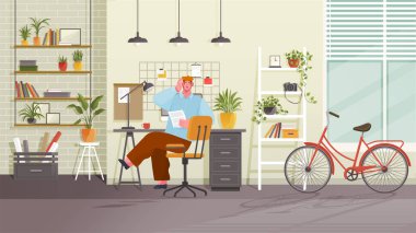 Man works at home office with cozy modern workplace, room with bike and houseplants. Remote employee on chair working online at desk with desktop computer and coffee cup. Tired or stressed man