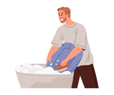 Kıyafet bakımı konsepti. Gülümseyen genç adam kirli çamaşırları kendi elleriyle yıkıyor deterjan ve plastik leğen kullanarak. Banyodaki sakallı erkek karakter gömleğini köpükle temizliyor.