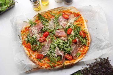 Kiraz domatesli pizza, İtalyan jambonu, peynir ve roka, en iyi manzara. Geleneksel İtalyan yemeği, jambonlu pizza. Dışarıda yemek yemek..