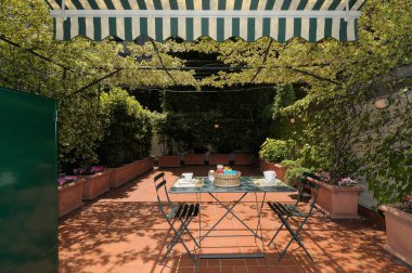 Milano 'nun merkezindeki bir apartmanın terasında kahvaltı için masa hazır.