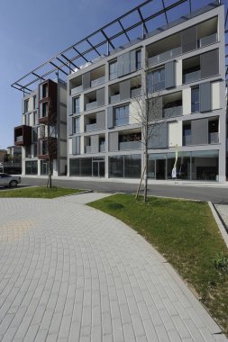 Como şehrinin kenar mahallelerindeki yeni bir yerleşim yerinin yürüyüş ve bahçesiyle dikey görüntü.