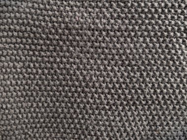 Yünlü kumaşın gri örülmüş dokusu. Tasarım için tekstil örgü desenli duvar kağıdı soyut arkaplan yüzeyi. El yapımı dükkanlar yumuşak, rahat arka planda mat ederler. Kış süveteri örülmüş makro fotoğraf.