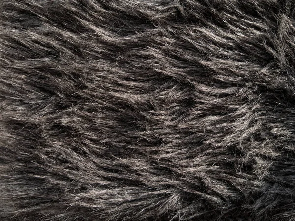 stock image Long gray fake fur texture cover. Synthetic fiber soft faux fur macro fabric photo. Monochrome fluffy furry surface for digital paper design Winter clothes coat backdrop Textile mat close-up wallpaper