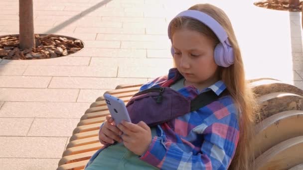 Blondynka Dzieci Słuchawki Kratkę Koszula Słuchać Muzyki Podcast Smartfon Poza — Wideo stockowe