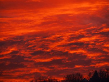 Turuncu gökyüzü ve bulutlarla dağlarda gün batımı. Kış Karpatları bulutlu manzaraya bakıyor. Avrupa, Ukrayna 'nın Transcarpathia kentindeki Karpatlar' daki Çam köknar ağacı ormanı Manzarası Köyü