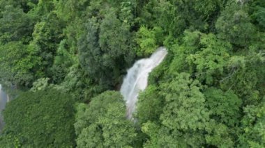 Tayland 'da şelaleli hava manzaralı yağmur ormanı manzarası. Kamera kayıtları, şelalenin hava görüntüleri. güzel doğal arkaplan.