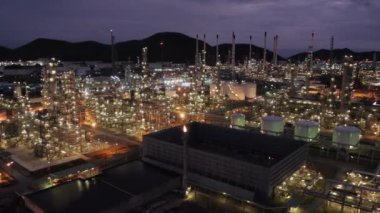 Işık yağı terminali ile uçan hava aracı petrol ve petrokimya depolama endüstriyel tesisidir. Petrol üretim ürünleri. Elektrik santrali. Az ışık. Rafineri b rulo drone atış 4k