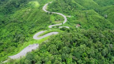 Yağmur mevsiminde, Nan, Tayland 'daki tropikal yağmur ormanları dağında, dolambaçlı yolun üzerinde uçan hava aracı. Broll görüntüleri, dolambaçlı ve tehlikeli yolların hava görüntüleri.