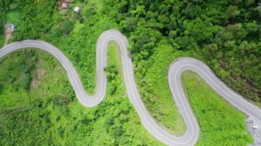 Yağmur mevsiminde, Nan, Tayland 'daki tropikal yağmur ormanları dağında, dolambaçlı yolun üzerinde uçan hava aracı. Broll görüntüleri, dolambaçlı ve tehlikeli yolların hava görüntüleri.