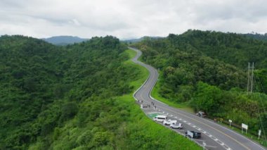 Yağmur mevsiminde, Nan, Tayland 'daki tropikal yağmur ormanları dağında, dolambaçlı yolun üzerinde uçan hava aracı. Broll görüntüleri, dolambaçlı ve tehlikeli yolların hava görüntüleri.