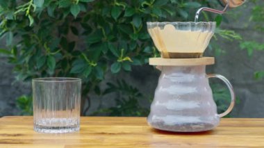 Fransız kahvesi demleniyor. Çaydanlıktan gelen sıcak suyu kahve zeminine dökerek tahtadan yeşil ağaç zeminli kahve çıkararak. Rahatlamaya kahve zamanı. Tatilde. Yavaş çekim 4k B-rulo.