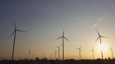 Rüzgar türbinlerinin enerji tasarrufu teknolojisi dünyayı kurtarmak için bir çözümdür. Gün batımında gökyüzünde çekilmiş. Güzel günbatımı gökyüzüne sahip rüzgar türbinleri. Küresel ısınma kavramı ve yeşil enerji. İklim değişikliği. Kamera B Kaydı