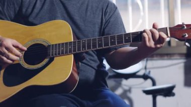Gitarist elleri gitar çalıyor. Gitar ve akor gitar çalan bir adam. Görüntü b-roll 4k.