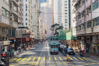 İnsanlar tramvayı kullanıyor. Hong Kong tramvayı, dünyada çift güverteli ve en önemli turistik yerlerden biri olan tek sistem..