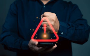 Uyarı işareti olan akıllı telefon kullanan bir adam. Uyarı hatası ve virüs tespit yazılımı. Akıllı telefondan acil durum alarmı. Veri ağı koruması. Virüs alarmı.