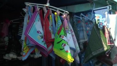 Dükkanda satılık bebek kıyafetleri yığını var.