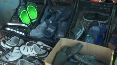 Karton bir kutuda lastik terlikler ve lastik botlar.