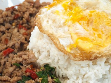 Kızarmış domuz pirzolası, kutsal fesleğen ve kızarmış yumurta. Ev yapımı Tayland yemeği..