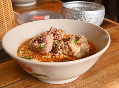 Baharatlı Tom YAM Ahşap masada domuz etli şehriye çorbası.