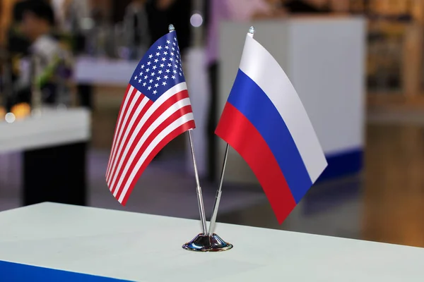 Two desktop flags of Russia and the USA together at some event or fair, as a symbol of cooperation between the two states. Joint business of the United States of America and the Russian Federation.