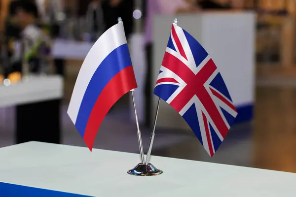 2 table flags of Russia and the United Kingdom together at some event or fair, as a symbol of cooperation between the two states. Joint business of Great Britain and the Russian Federation.