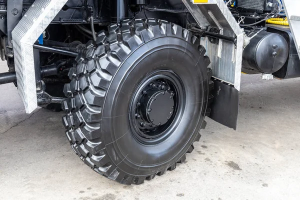 A new rubber truck tire or an off-road vehicle. Off-road capability, the tread or protector. The auto store or dealership or modern truck exhibition.