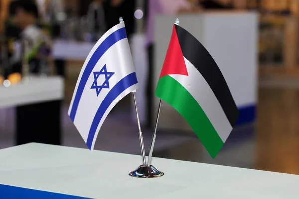 Small tabletop flags of Israel and Palestine together at some event or fair. Flags of two countries as a symbol of cooperation between states. Joint business between Palestine and Israel.