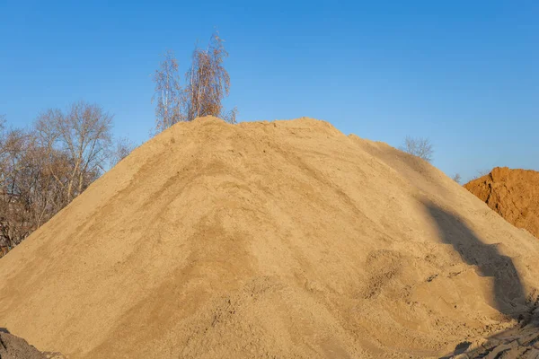 A pile of sand at a construction site. Bulk material for infrastructure construction and repair.