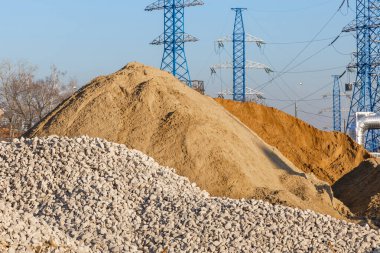 İnşaat alanı. Moloz ve kumdan tepeler ve yüksek voltajlı sütunlar. Yeni bir otoyol inşaatı, yol onarımı, yeraltı borularının döşenmesi ve elektrik iletişimi..