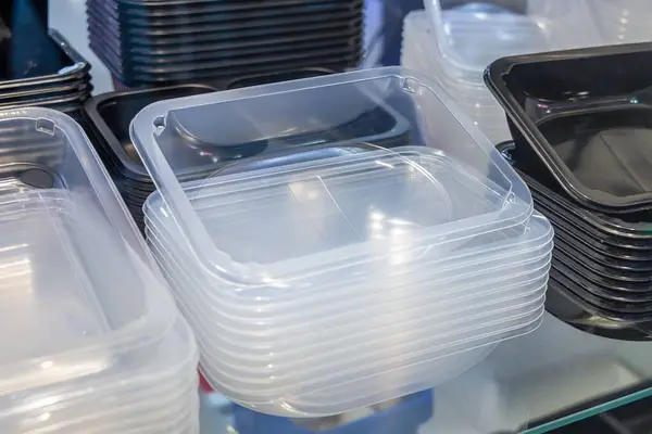 Stacks of plastic food trays for packaging and transporting takeaway food, or for packaging ready meals in supermarkets. Disposable plastic packaging.