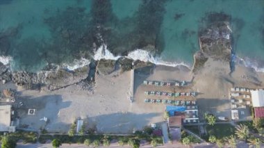 Bu video Türkiye 'de Akdeniz kıyısındaki bir plajın 8K çözünürlükteki havadan görüntüsünü gösteriyor