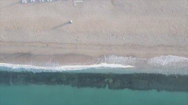 Bu video Türkiye 'de Akdeniz kıyısındaki bir plajın 8K çözünürlükteki havadan görüntüsünü gösteriyor