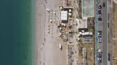 Bu video Türkiye 'de Akdeniz kıyısındaki bir plajın 8K çözünürlükteki havadan görüntüsünü gösteriyor