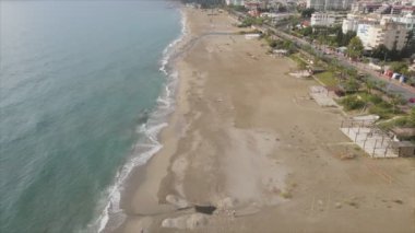 Bu video Türkiye 'de Akdeniz kıyısındaki bir plajın 8K çözünürlükteki havadan görüntüsünü gösteriyor