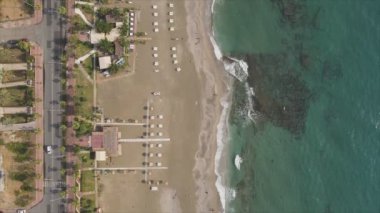 Bu video Türkiye 'de Akdeniz kıyısındaki bir plajın 8K çözünürlükteki havadan görüntüsünü gösteriyor