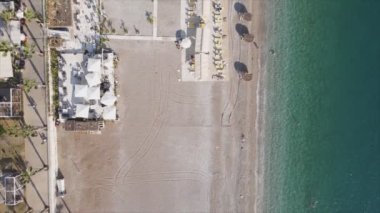 Bu video Türkiye 'de Akdeniz kıyısındaki bir plajın 8K çözünürlükteki havadan görüntüsünü gösteriyor