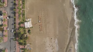 Bu video Türkiye 'de Akdeniz kıyısındaki bir plajın 8K çözünürlükteki havadan görüntüsünü gösteriyor