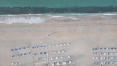 Bu video Türkiye 'de Akdeniz kıyısındaki bir plajın 8K çözünürlükteki havadan görüntüsünü gösteriyor